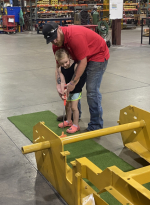 weiler employee helps his child play mini golf